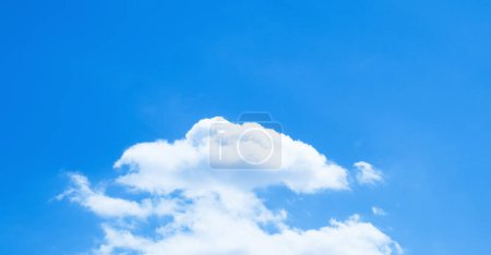Natural small cottony fluffy white cloud in blue sky. Sky background image. Empty area copy space for text.