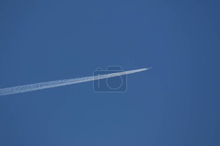 Téléchargez les photos : Un avion et des traînées de vapeur dans le ciel - en image libre de droit