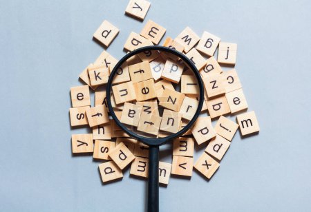 Englisches Alphabet aus quadratischen Holzfliesen mit dem englischen Alphabet auf blauem Hintergrund. Das Konzept der Denkentwicklung, der Grammatik.