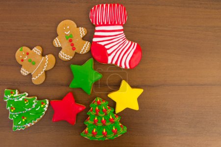 Photo for Tasty festive Christmas cookies in the shape of Christmas tree, Gingerbread man, star and Christmas sock on wooden table. Top view - Royalty Free Image