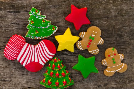 Photo for Tasty festive Christmas cookies in the shape of Christmas tree, Gingerbread man, star and Christmas sock on rustic wooden table. Top view - Royalty Free Image