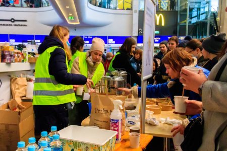 Téléchargez les photos : Varsovie, Pologne - 9 mars 2022 : Des volontaires aident les réfugiés ukrainiens à la gare de Varsovie, en Pologne - en image libre de droit