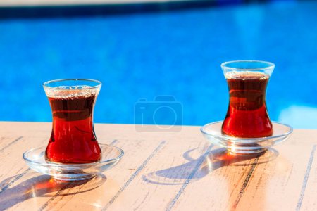 Téléchargez les photos : Thé turc chaud sur une table près d'une piscine - en image libre de droit