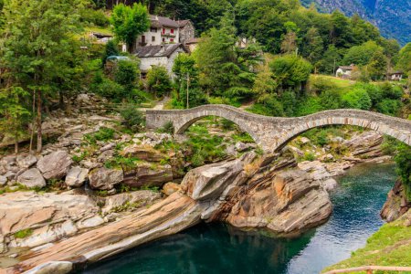 Photo for Ancient double arch stone Roman bridge (Ponte dei Salti) over the clear water of the Verzasca river in Lavertezzo ,Verzasca Valley, Ticino Canton, Switzerland - Royalty Free Image