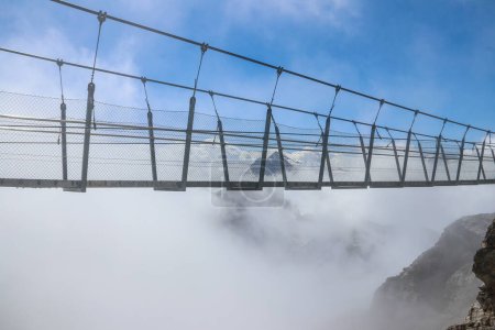 Photo for Titlis suspension bridge of steel crossing the peak on top of Titlis glacier in the Uri Alps, Engelberg, Switzerland. Highest suspension bridge in Europe - Royalty Free Image