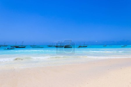 Téléchargez les photos : Vue sur la plage de sable tropical Nungwi et les bateaux traditionnels en bois dans l'océan Indien sur Zanzibar, Tanzanie - en image libre de droit