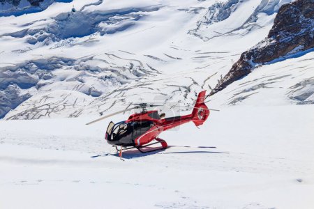 Roter Hubschrauber auf Jungfrau im Berner Oberland gelandet