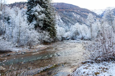 Blick auf den Winterfluss in den Schweizer Alpen, Schweiz. Verschneite Gebirgsflusslandschaft