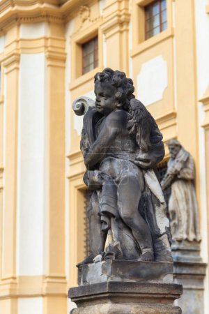 Foto de Estatua barroca ante la fachada del monasterio de Loreta en Praga, República Checa - Imagen libre de derechos