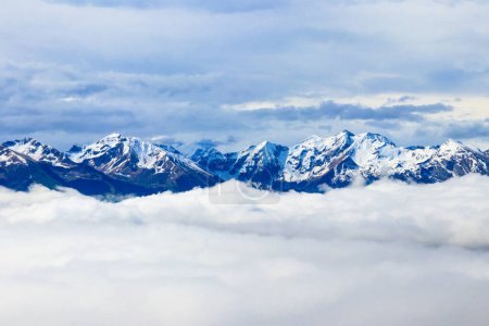 Beautiful view of snow-capped mountains above thick clouds in Bernese Oberland, Switzerland