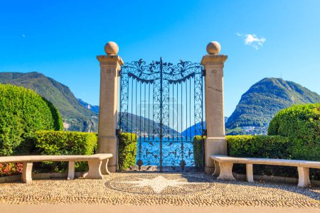 Puerta de hierro forjado antigua con vistas al lago Lugano en el Parque Ciani, Lugano, Suiza