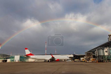 Schöner Regenbogen über dem Basler Euroairport. Flugzeug am Tor geparkt