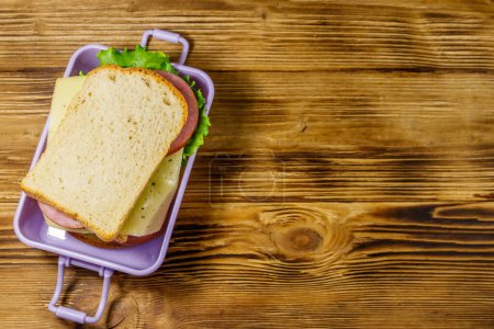 Boîte à lunch avec sandwichs sur une table en bois. Vue du dessus, espace de copie