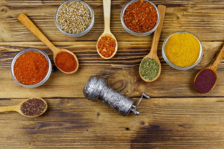 Photo for Set of different aromatic spices and spice mill on wooden table. Top view - Royalty Free Image