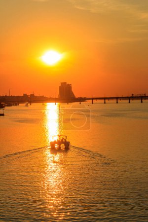Modern yacht sailing on the Dnieper river at sunset in Dnipro, Ukraine