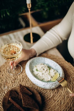 Téléchargez les photos : Femme avec un bol de riz et un verre de lait sur une table en bois - en image libre de droit