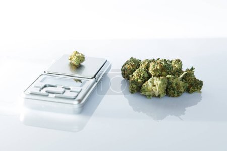 Cannabis flos, medizinisches Marihuana neben Präzisionswaage, sichere Einnahme von Medikamenten