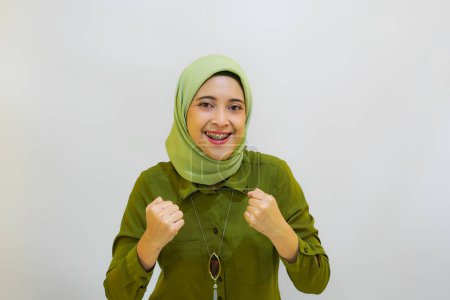 Foto de Feliz y alegre chica asiática joven con camisa verde. concepto de publicidad aislado sobre fondo blanco - Imagen libre de derechos