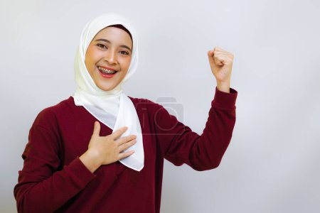 Cheerful Asian muslim woman showing high spirit during independence day celebration, isolated by white background. Indonesia's independence day concept.     