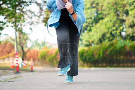Sporty woman running on the road in the morning. Fitness and workout wellness concept.