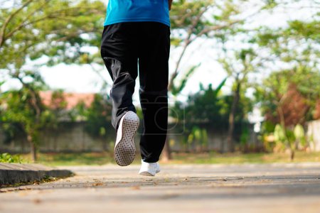 Sporty man running on the road in the morning. Fitness and workout wellness concept.