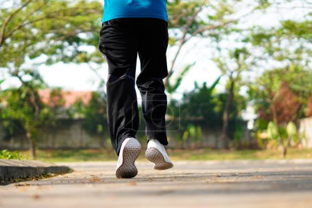 Foto de Hombre deportivo corriendo en la carretera por la mañana. Fitness y entrenamiento concepto de bienestar. - Imagen libre de derechos