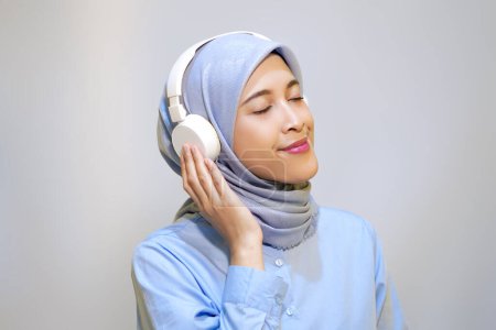 Photo for Cute young muslim woman enjoying music with headphone on. Enjoying music concept - Royalty Free Image