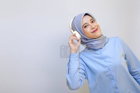  Cute young muslim woman enjoying music with headphone on. Enjoying music concept                              