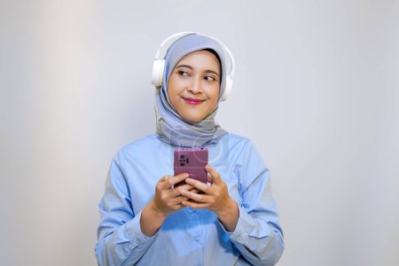 Cute young muslim woman enjoying music with headphone on. Enjoying music concept