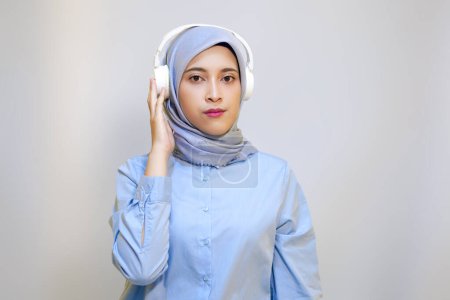 Cute young muslim woman enjoying music with headphone on. Enjoying music concept