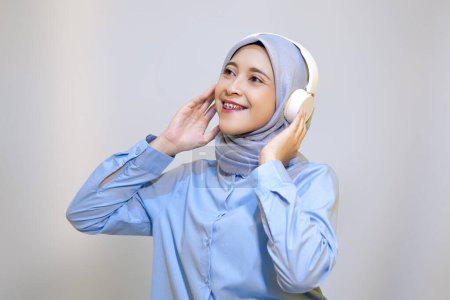Foto de Linda joven musulmana mujer disfrutando de la música con auriculares. Disfrutando del concepto musical - Imagen libre de derechos