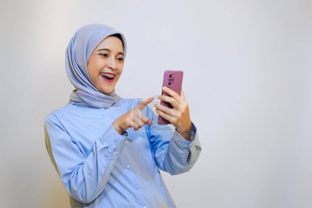 Photo for Young muslim woman cheerfully online shopping on her phone. online shopping concept with mobile phone - Royalty Free Image