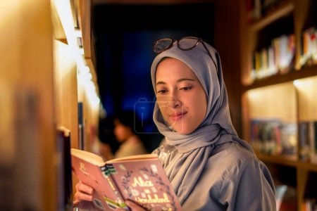 Heureusement jeune femme musulmane appréciant les livres à la bibliothèque. concept de bibliothèque