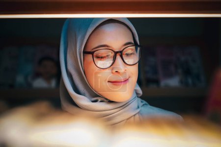 Happily young muslim woman enjoying books at the library. library concept