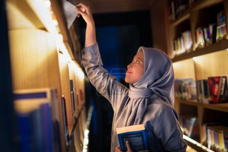 Glücklich junge muslimische Frau genießt Bücher in der Bibliothek. Bibliothekskonzept