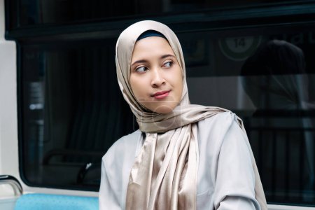 Mujer musulmana asiática en el sistema de transporte público de trenes subterráneos. Concepto de transporte público