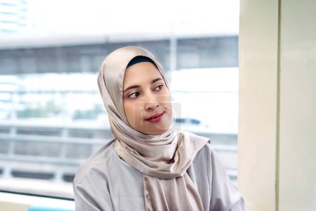 Mujer musulmana asiática en el sistema de transporte público de trenes subterráneos. Concepto de transporte público