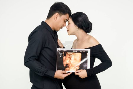 Junges Paar zeigt Ultraschallbild ihres Babys, Fokus auf Ultraschallbild