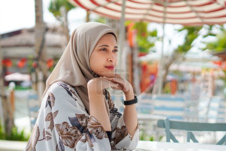 Contemplación junto al mar. Mujer musulmana feliz disfrutando del ambiente de playa
