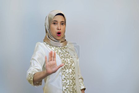 Mujer indonesia posando con la palma abierta como si prohibiera a alguien