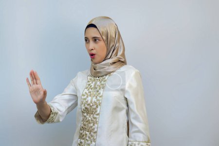 Femme indonésienne posant avec la paume ouverte comme si elle interdisait quelqu'un