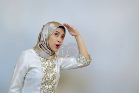 Mujer musulmana joven con entusiasmo mirando hacia arriba y mirando a la distancia. Curioso acerca de algo concepto