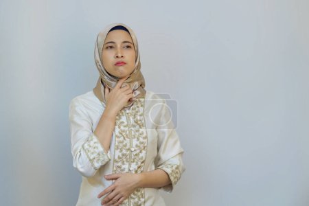 Mujer musulmana indonesia expresando sed y malestar durante el ayuno del Ramadán sobre fondo blanco