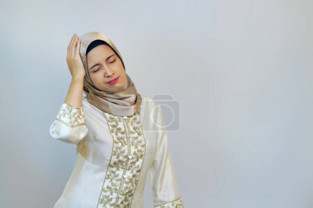 Indonesian Hijabi Woman Expressing Migraine Pain During Ramadan on White Background