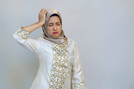 Indonesian Hijabi Woman Expressing Migraine Pain During Ramadan on White Background