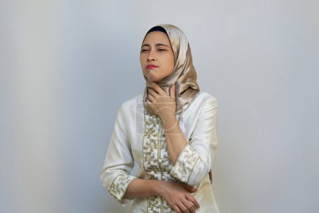 Indonesische Muslimin drückt während des Ramadan-Fastens auf weißem Hintergrund Durst und Unbehagen aus