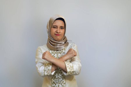 Indonesische Hijabi-Frau gestikuliert mit der Hand oder formt X-Form