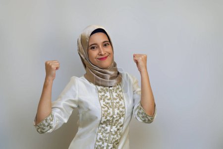 Mujer musulmana indonesia celebrando el éxito en Ramadán sobre fondo blanco