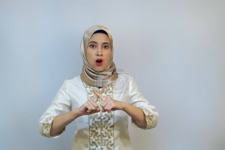 Mujer hijabi indonesia haciendo gestos prohibición con la mano o formando forma de X