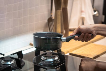 Man turning on his stove to boil something concept